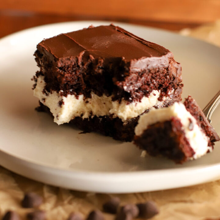 slice of chocolate layer cake with cream filling with a bite taken out of it