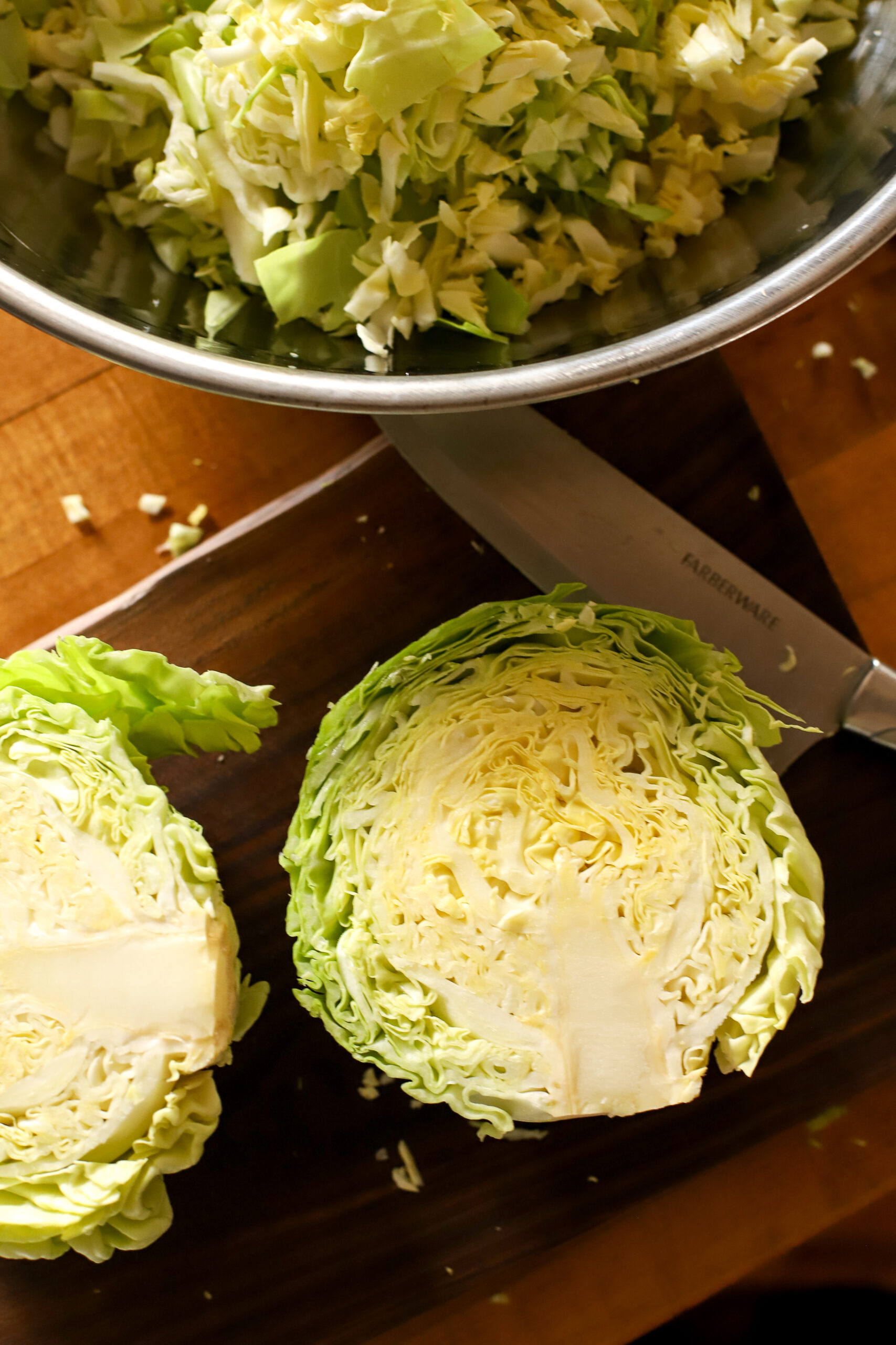 close up shot of cabbage and shredded cabbage when making homemade sauerkraut