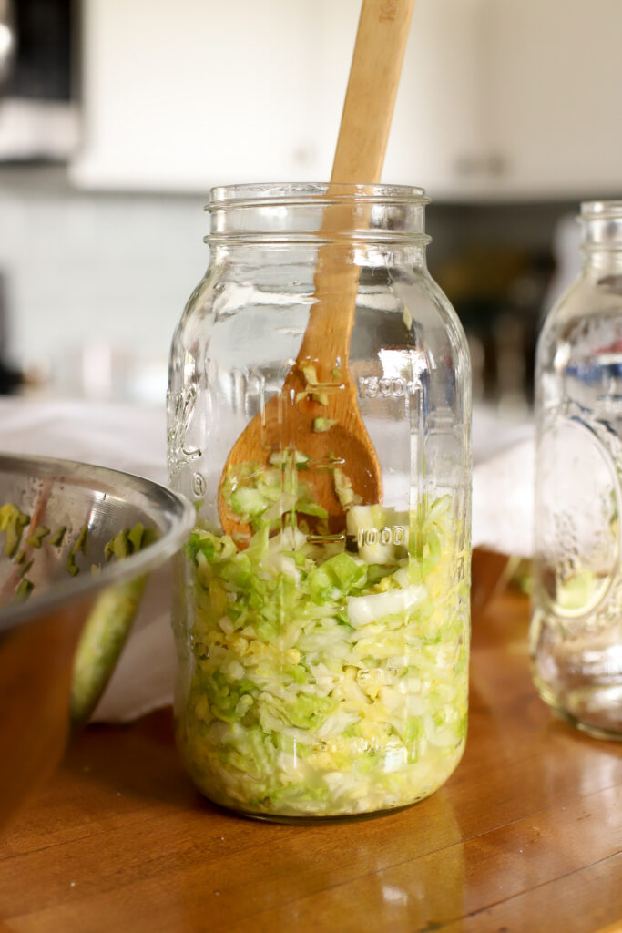 half gallon jar being filled with cabbage
