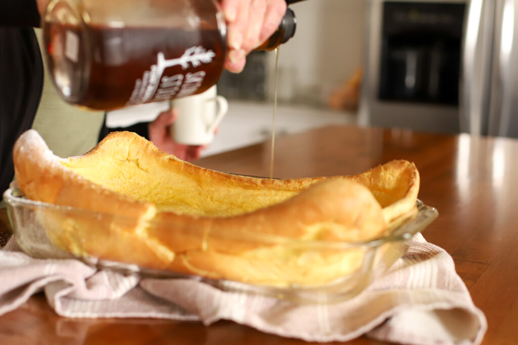 pouring maple syrup over pancakes