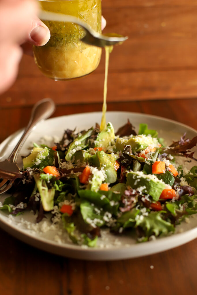 image of salad being topped with the best simple salad vinaigrette
