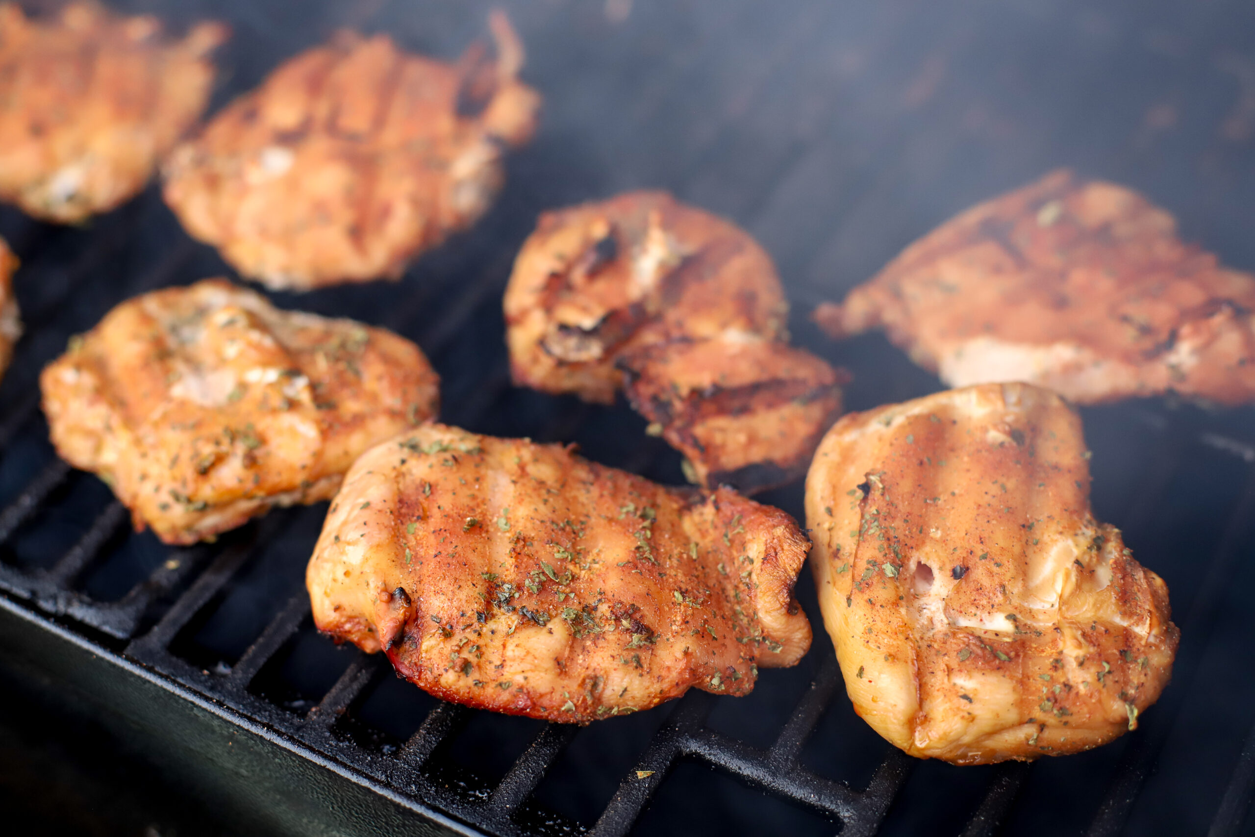 image of chicken breasts smoking on pellet grill