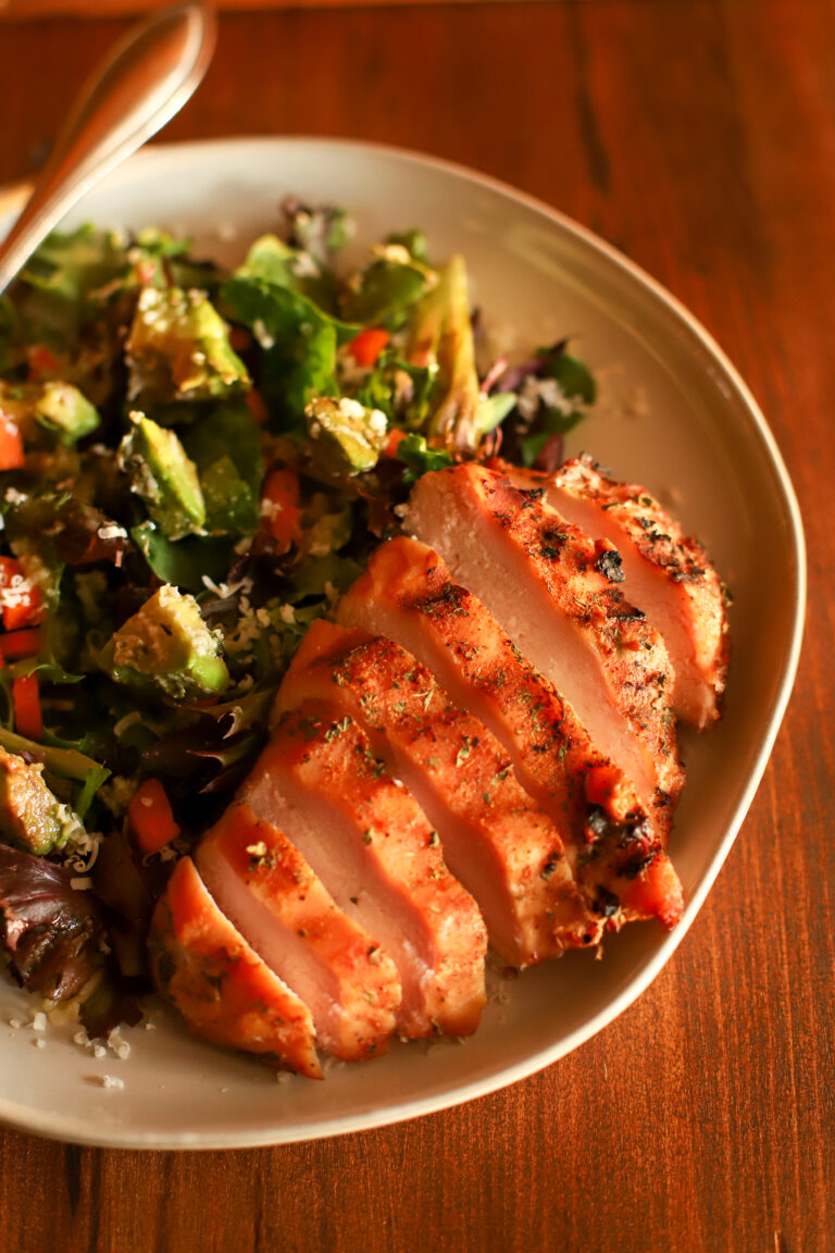 image of sliced smoked chicken breast on a plate with salad