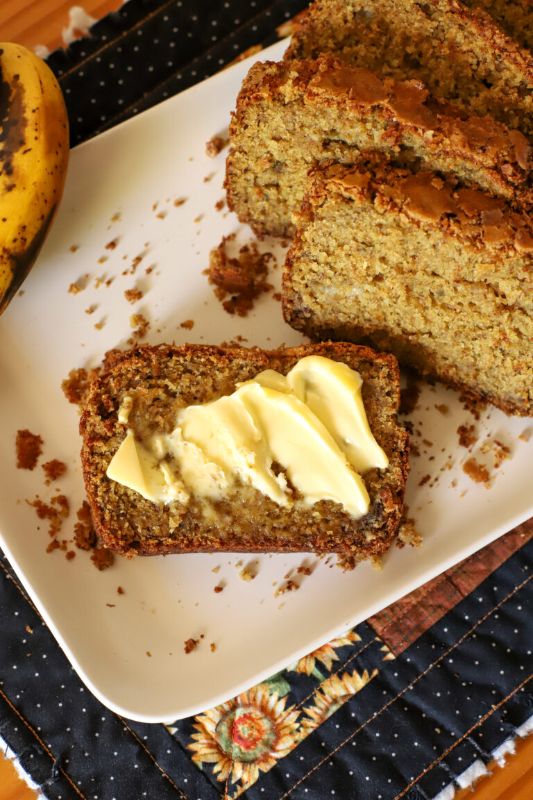 slice of freshly milled banana bread with butter on a plate