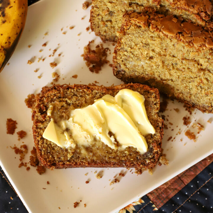 slice of freshly milled banana bread with butter on a plate