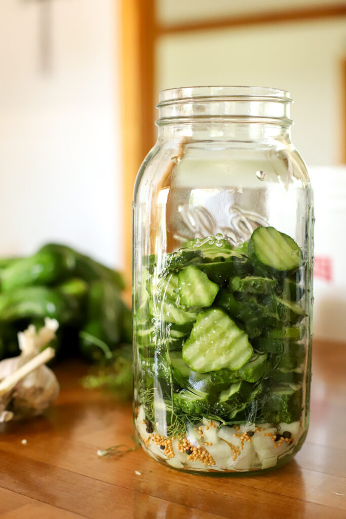 filling the jar of fermented cucumbers