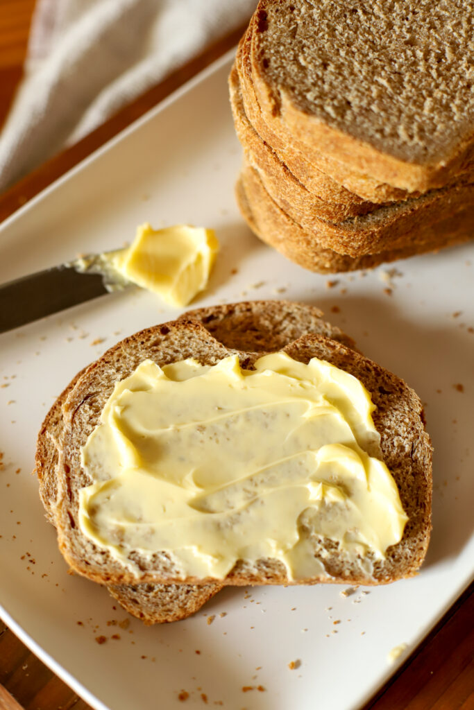 up close shot of buttered freshly milled sourdough sandwich bread