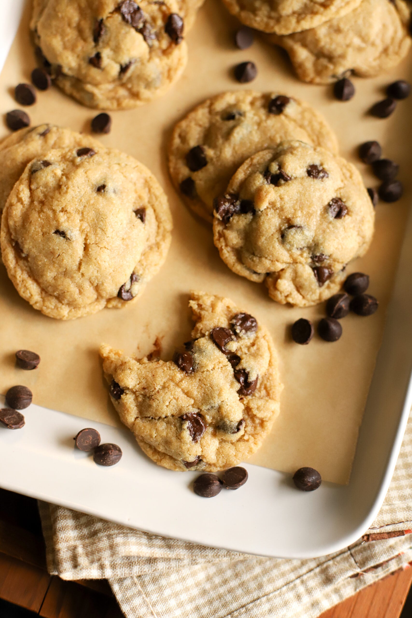 up close shot of a fresh milled cookie with a bite taken out of it on a tray with other freshly milled chocolate chip cookies