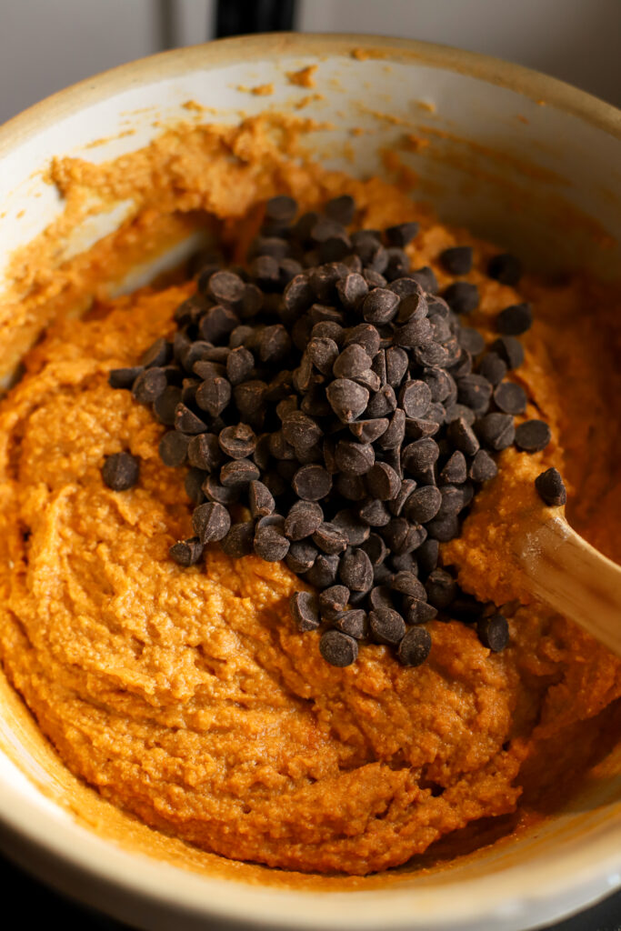 up close shot of chocolate chips being added to muffin batter