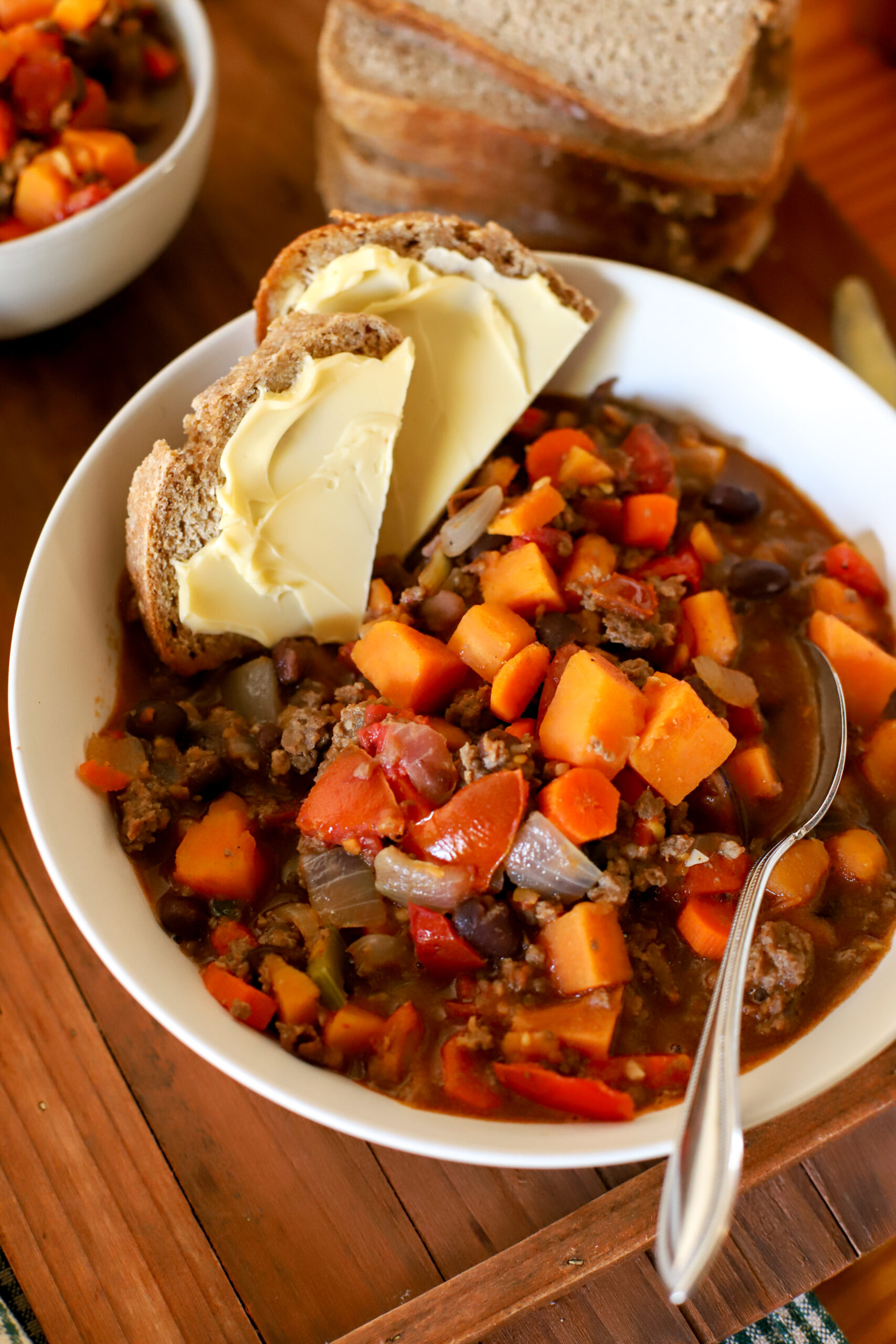 up close image of chili in a bowl with buttered bread