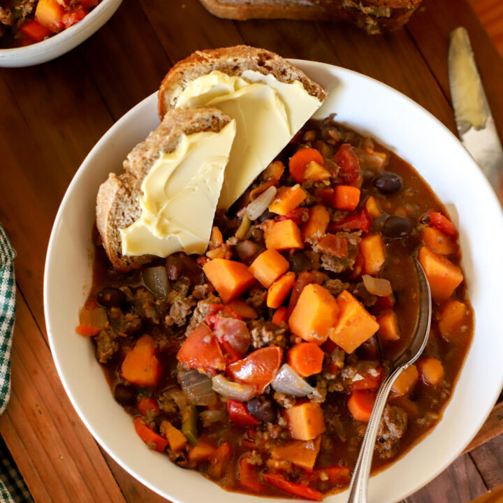 a bowl of harvest chili with buttered bread