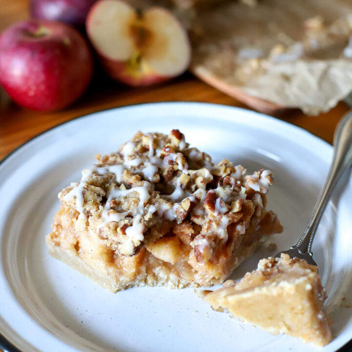 up close shot of apple pie bars on a plate with a bite taken out