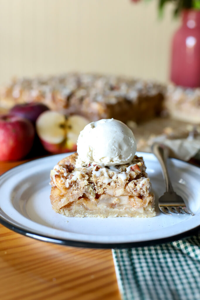 up close shot of freshly milled apple pie bars with vanilla ice cream on top