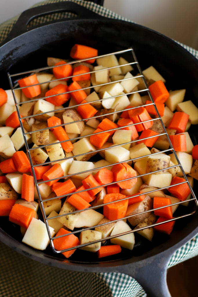 diced vegetables in a cast iron skillet with rack on top