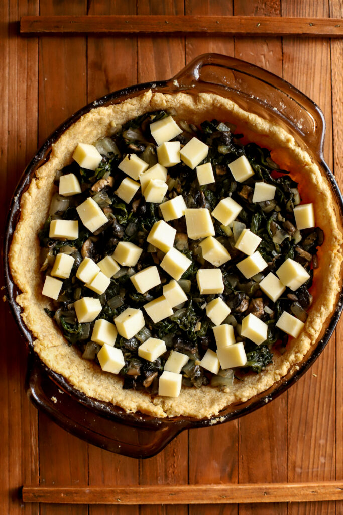 up close shot of cheese and vegetables in a pie crust