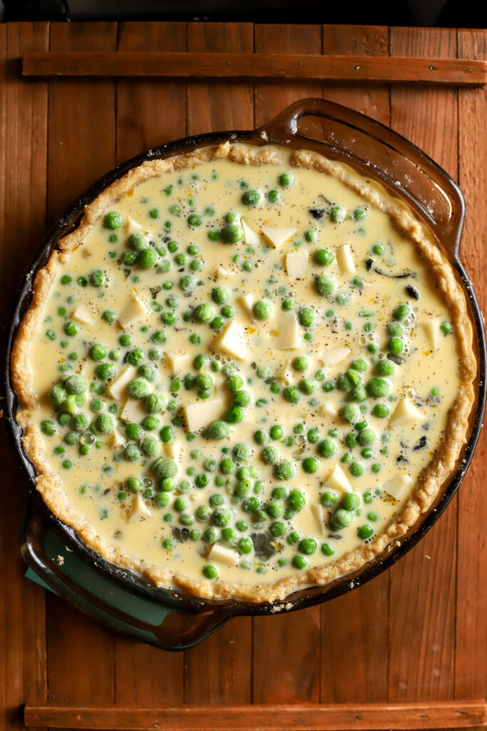 up close shot of unbaked vegetable quiche with fresh milled crust