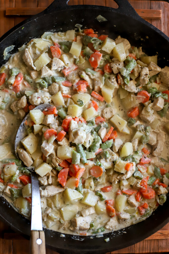 up close shot of chicken pot pie filling in a cast iron skillet