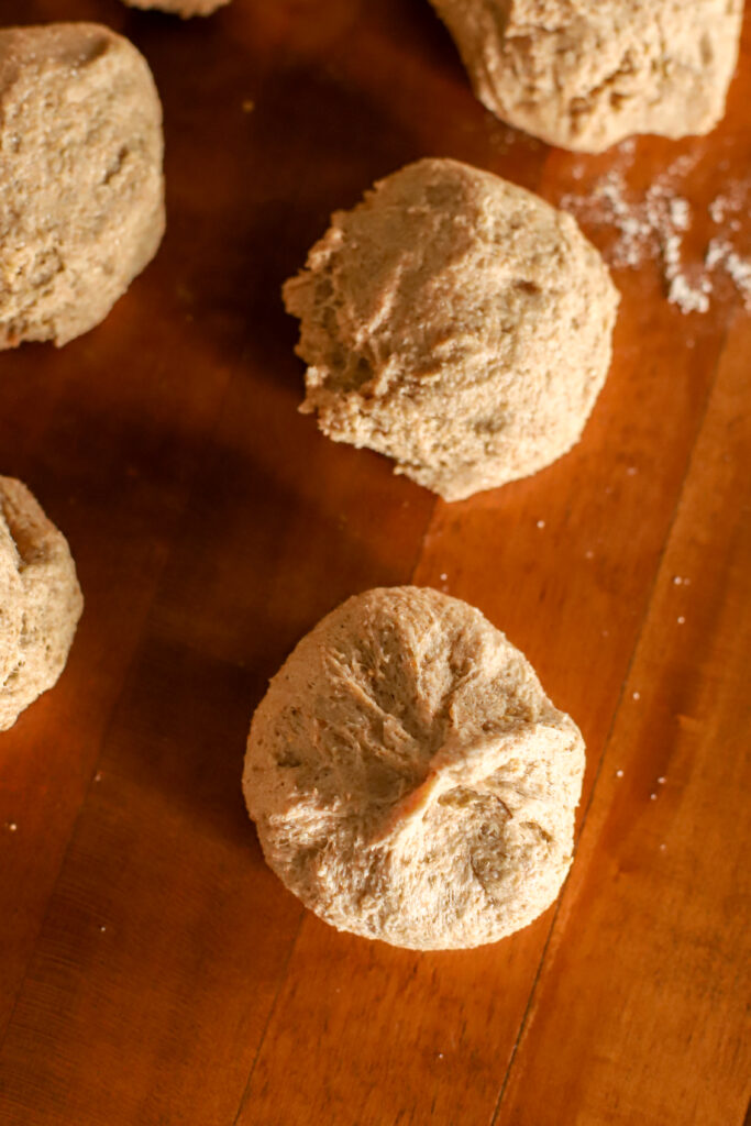 up close shot of shaping a fresh milled sourdough dinner roll
