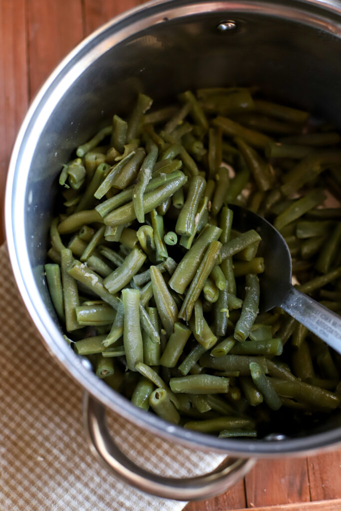 up close shot of frozen green beans cooked in a medium sized pan