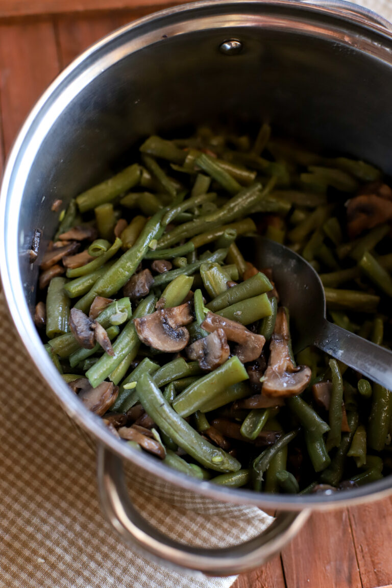 up close shot of frozen green beans cooked in a medium sized pan with mushrooms