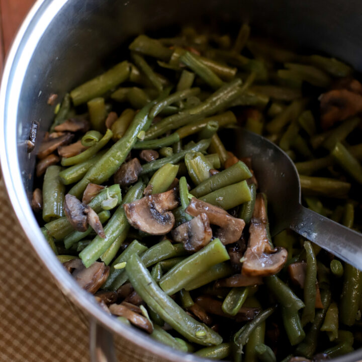up close shot of frozen green beans cooked in a medium sized pan with mushrooms