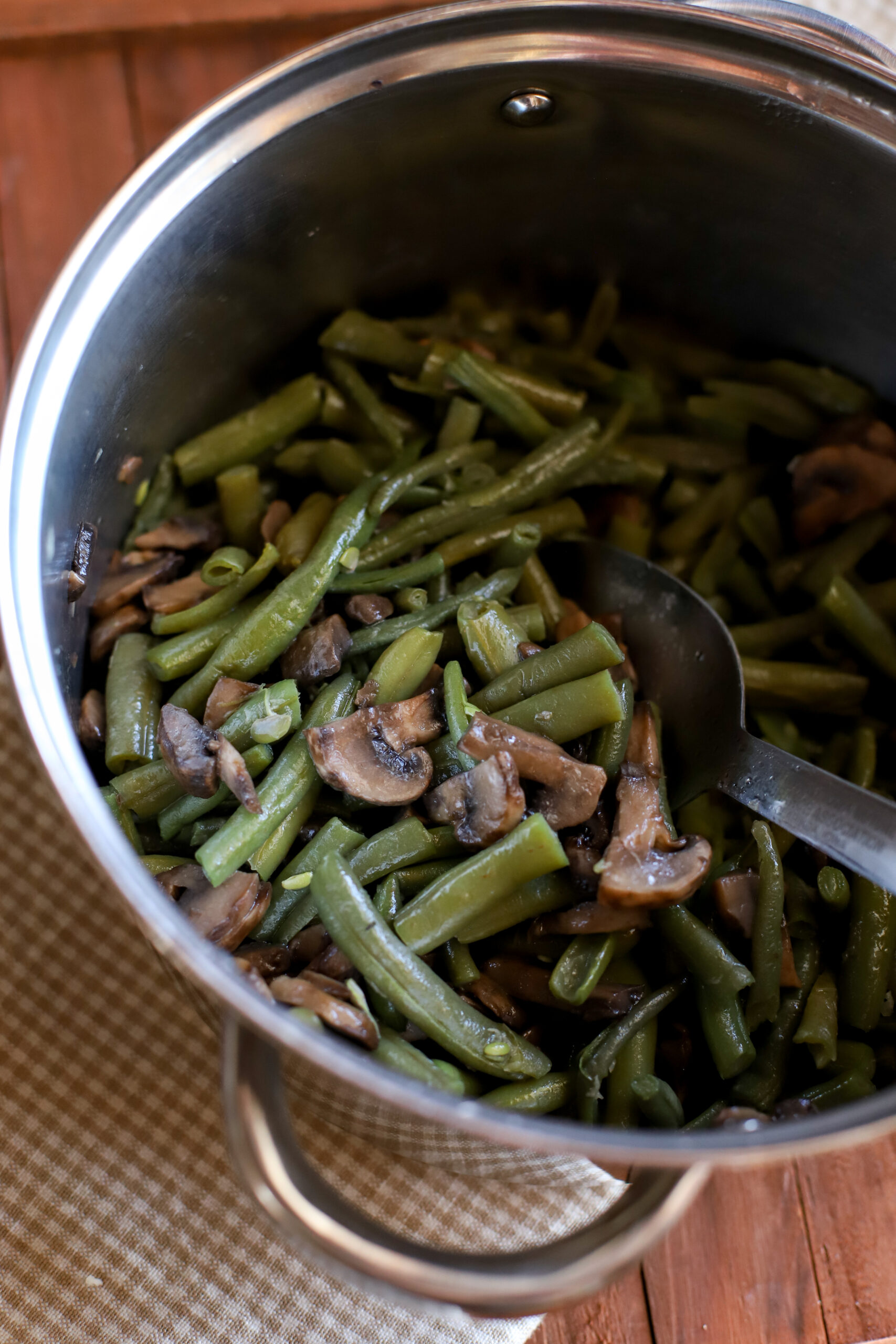 up close shot of frozen green beans cooked in a medium sized pan with mushrooms