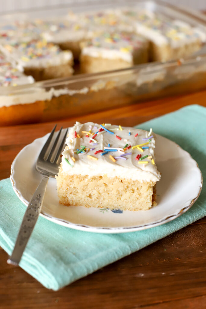 up close shot of a slice of fresh milled cake on a small plate with a fork