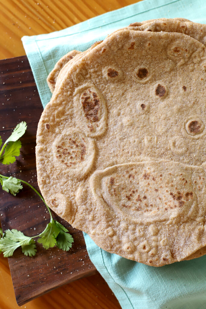 an overhead shot of a fresh milled tortilla on a light blue towel