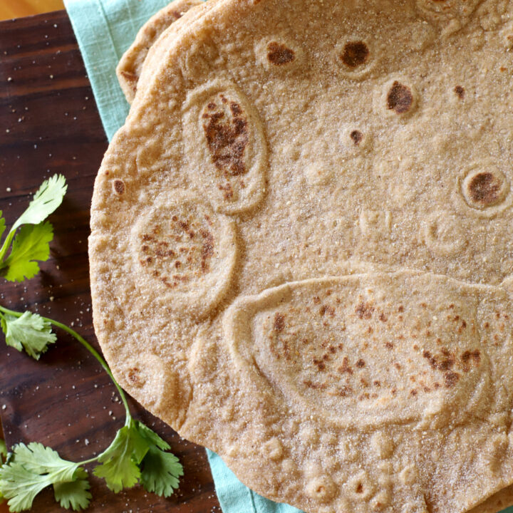 an overhead shot of a fresh milled sourdough tortilla on a light blue towel