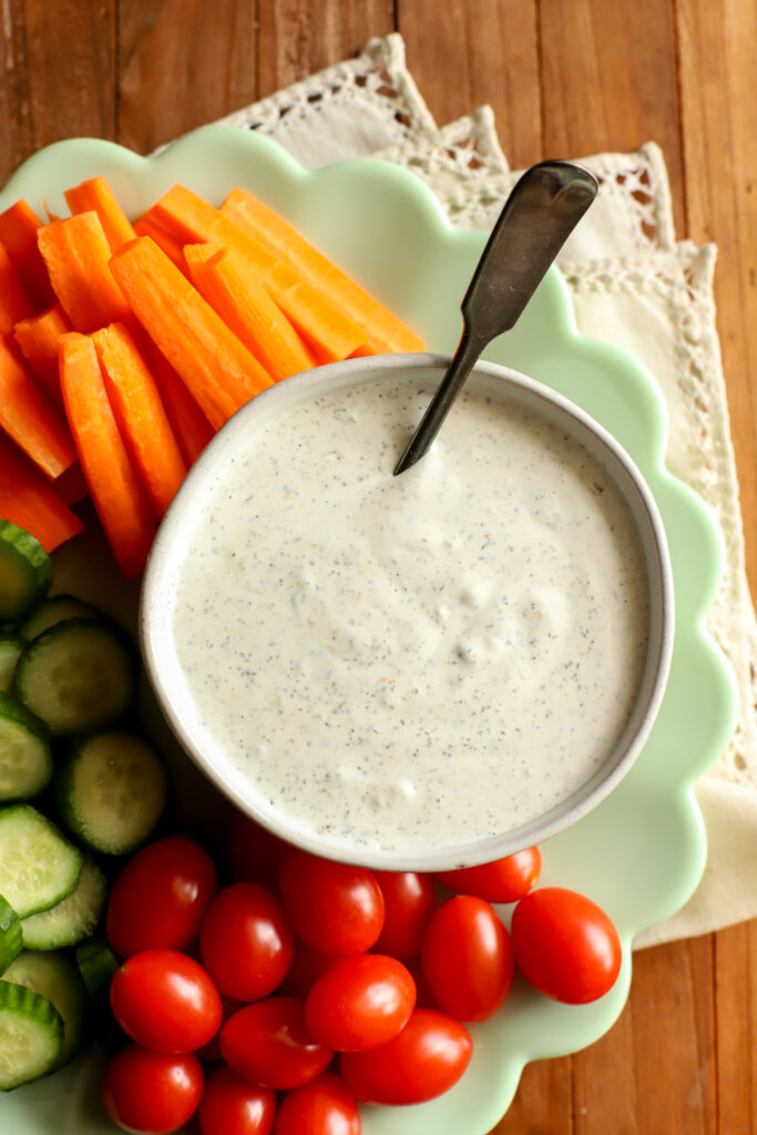 up close shot of a plate filled with vegetables and a bowl of homemade ranch dressing