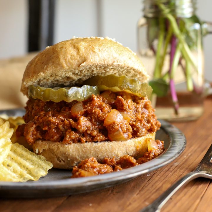 up close shop of easy sloppy joe recipe on a fresh milled sourdough bun with pickles