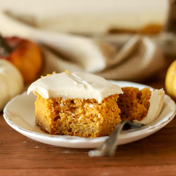 an up close shot of a slice of fresh milled pumpkin cake topped with buttercream frosting