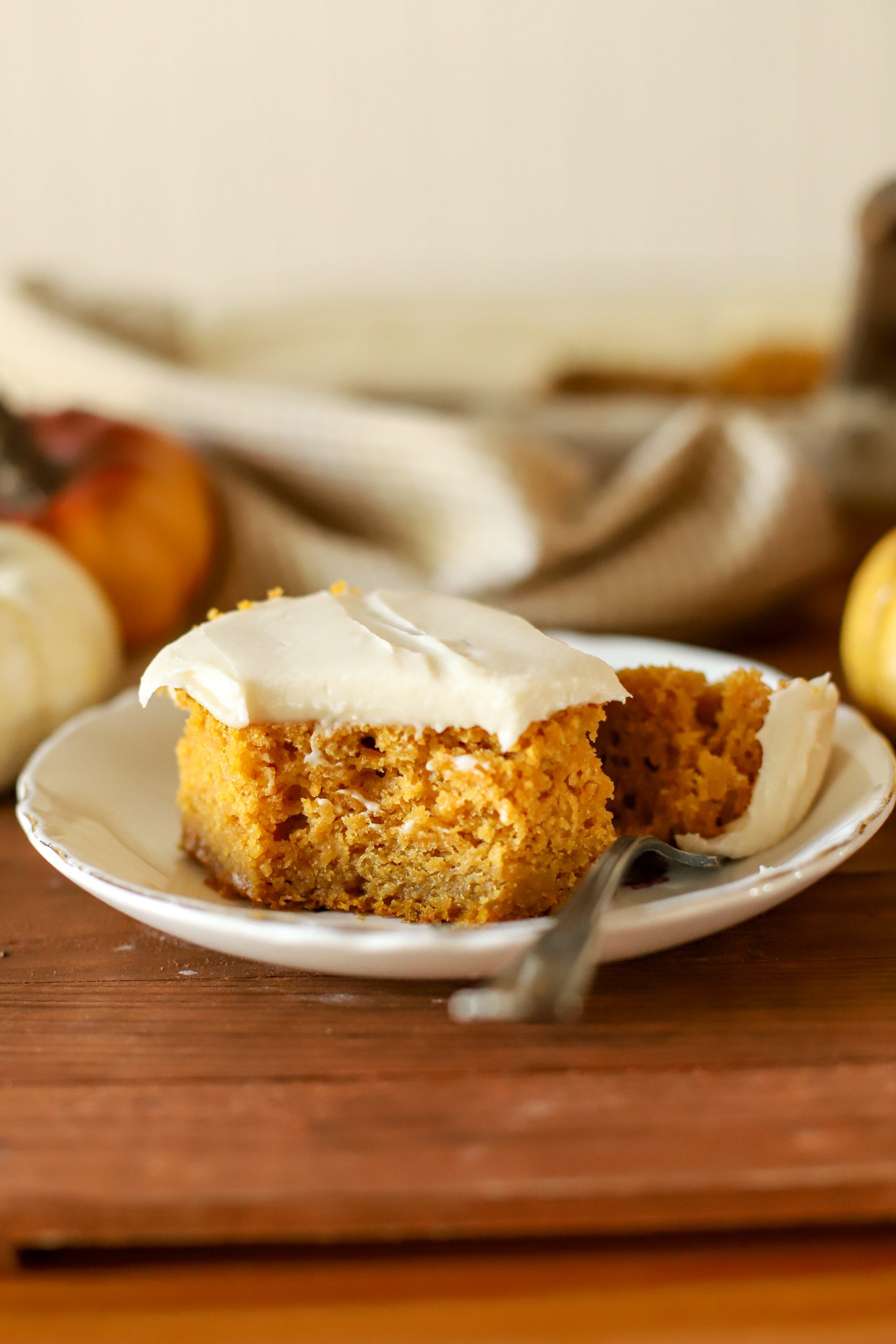 an up close shot of a slice of fresh milled pumpkin cake topped with buttercream frosting