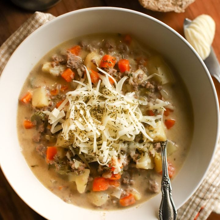 up close shot of a bowl of cheeseburger soup with shredded cheese on top