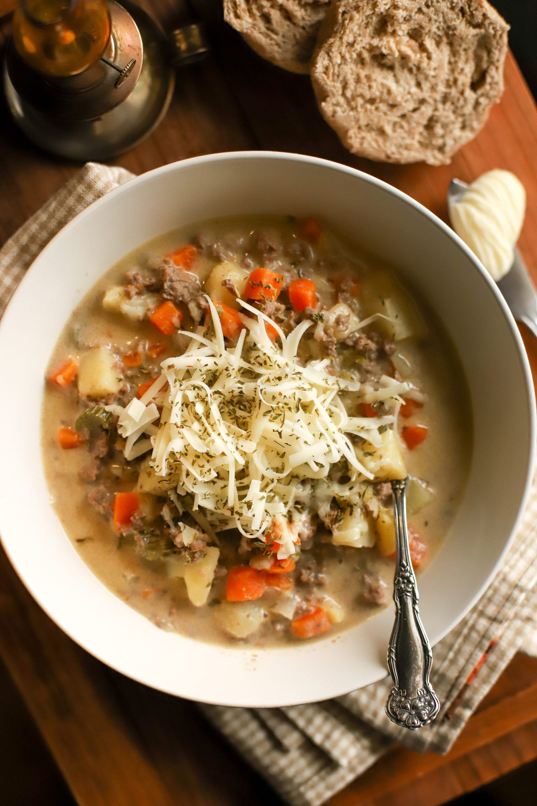 up close shot of a bowl of cheeseburger soup with shredded cheese on top