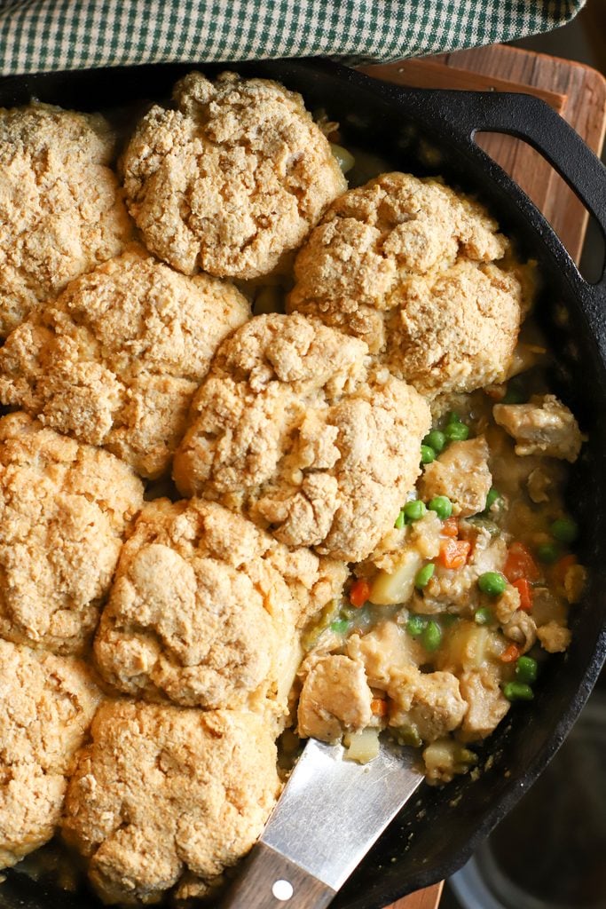 an overhead shot of a cast iron pan with creamy chicken pot pie with fresh milled biscuits