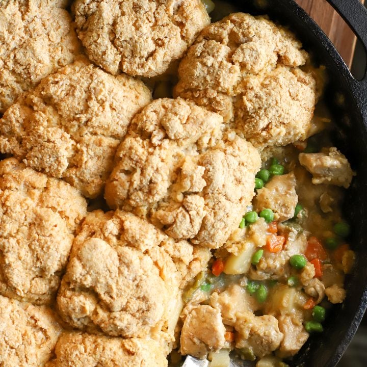 an overhead shot of a cast iron pan with creamy chicken pot pie with fresh milled biscuits